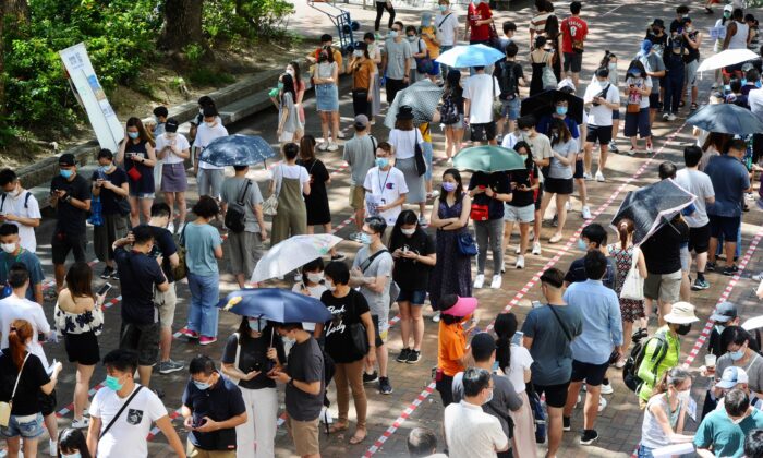 Los votantes hacen cola en largas filas esperando para emitir sus votos en las elecciones primarias del 12 de julio de 2020. (Song Bilung/The Epoch Times)