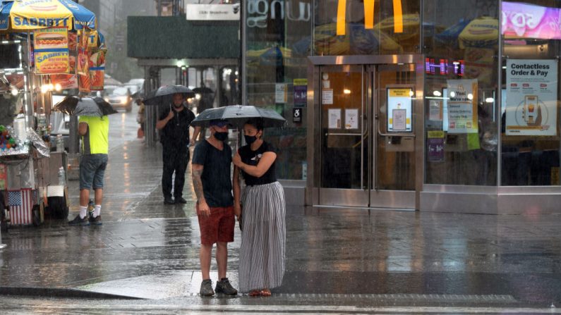 La gente pasa por Times Square bajo la lluvia mientras la tormenta tropical Fay llega el 10 de julio de 2020 a la ciudad de Nueva York. (Foto de David Dee Delgado/Getty Images)