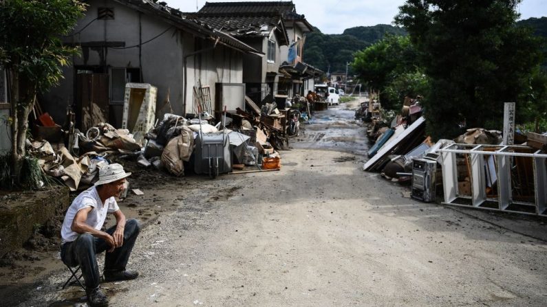 Un hombre se sienta frente a su casa como pertenencias personales fueron destruidas por la reciente inundación en la zona de Hitoyoshi, prefectura de Kumamoto el 8 de julio de 2020. (Foto de CHARLY TRIBALLEAU/AFP vía Getty Images)