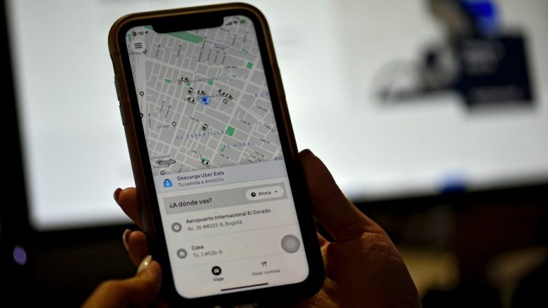 Una mujer revisa la solicitud de transporte de Uber en su teléfono móvil en Colombia, el 20 de diciembre de 2019. (Foto de JUAN BARRETO/AFP vía Getty Images)