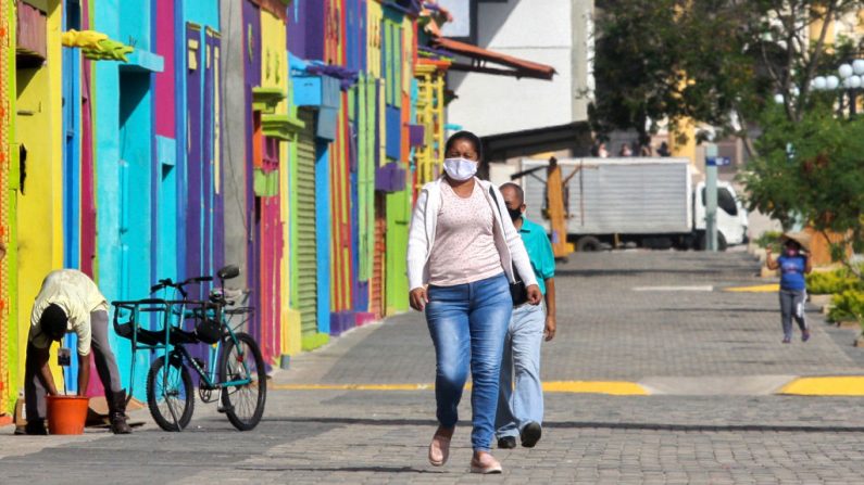 La gente usa máscaras faciales mientras camina por una calle de Maracaibo, Estado Zulia, Venezuela, el 2 de julio de 2020, en medio de la pandemia del COVID-19. (Foto de LUIS BRAVO/AFP vía Getty Images)