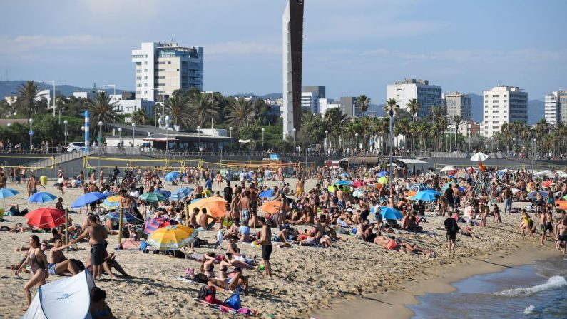 La gente nada y toma el sol en la playa de Bogatell en Barcelona (España), una de las varias arenas de la ciudad que han sido cerradas el 19 de julio de 2020 debido a que se ha alcanzado la capacidad permitida. (Foto de JOSEP LAGO/AFP vía Getty Images)