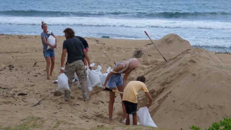 Los residentes de barlovento llenan bolsas de arena en preparación para los efectos del huracán Douglas en Oahu, Hawái, el 25 de julio de 2020. (Foto de RONEN ZILBERMAN/AFP vía Getty Images)