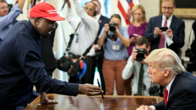 El rapero Kanye West , a la izquierda, muestra una foto al Presidente de los EE.UU. Donald Trump durante una reunión en el despacho oval de la Casa Blanca el 11 de octubre de 2018 en Washington, DC. (Oliver Contreras - Pool/Getty Images)
