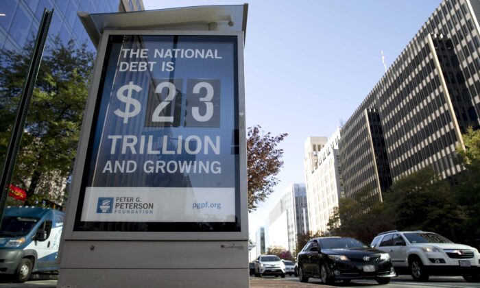 Un cartel que muestra la deuda nacional y la parte de cada estadounidense se exhibe en Washington, D.C., el 6 de noviembre de 2019. La cifra luego ascendió a más de USD 26,500 millones (Tasos Katopodis/Getty Images para 