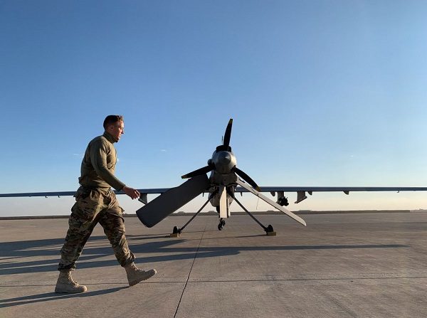 Un miembro de las fuerzas de EE.UU. pasa por delante de un avión teledirigido en la base aérea de Ain al-Asad, en la provincia iraquí occidental de Anbar, el 13 de enero de 2020. (AYMAN HENNA/AFP vía Getty Images)
