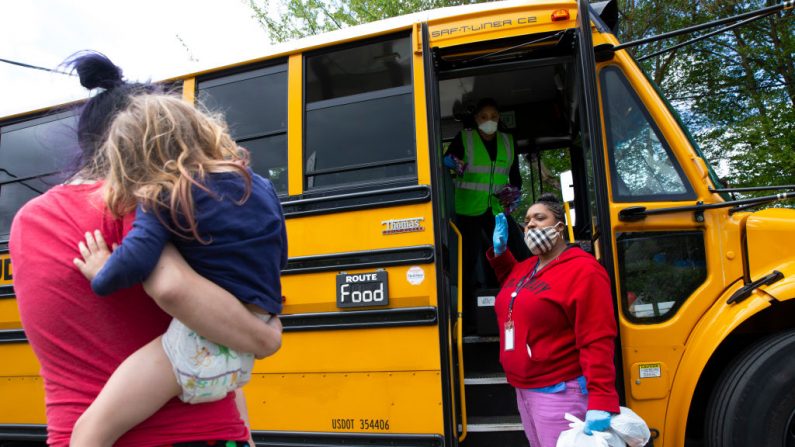 El conductor del autobús Treva White y la nutricionista Shaunté Fields entregan comidas a los niños y sus familias el 6 de mayo de 2020 en Seattle, Washington. (Karen Ducey/Getty Images)	