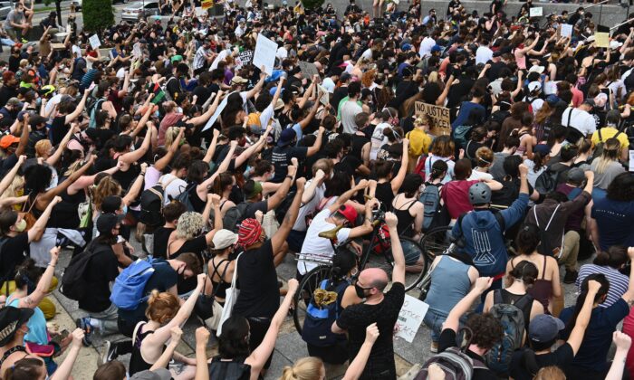 Los manifestantes se arrodillan y levantan los puños durante una manifestación de "Black Lives Matter" frente a la Biblioteca de Brooklyn y Grand Army Plaza en Brooklyn, Nueva York, el 5 de junio de 2020. (Angela Weiss/AFP a través de Getty Images)
