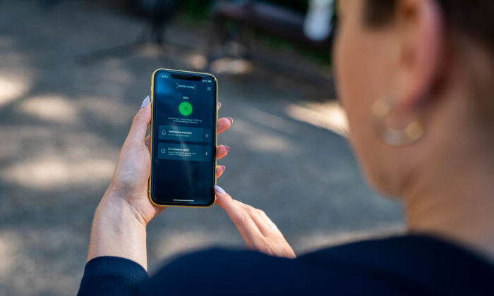 Una mujer sostiene un smartphone que muestra una nueva aplicación oficial de rastreo de infecciones por COVID-19 en Copenhague. Dinamarca, el 18 de junio de 2020. (Martin Sylvest/Ritzau Scanpix/AFP vía Getty Images)