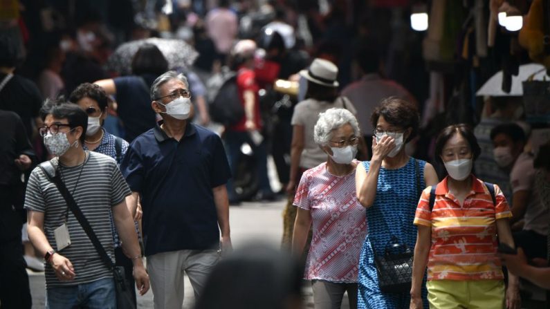 Peatones con máscaras faciales caminan por un mercado en el centro de Seúl (Corea del Sur) el 23 de junio de 2020. (Foto de JUNG YEON-JE/AFP vía Getty Images)