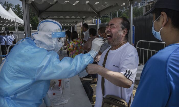Un residente de Beijing recibe la prueba del hisopo de ácido nucleico para detectar COVID-19 en un lugar de pruebas en Beijing el 1 de julio de 2020. (Kevin Frayer/Getty Images)