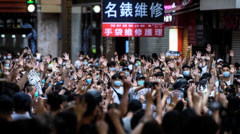 Los manifestantes cantan eslóganes y hacen gestos durante una manifestación contra una nueva ley de seguridad nacional en Hong Kong el 1 de julio de 2020. (Foto de ANTHONY WALLACE/AFP vía Getty Images)