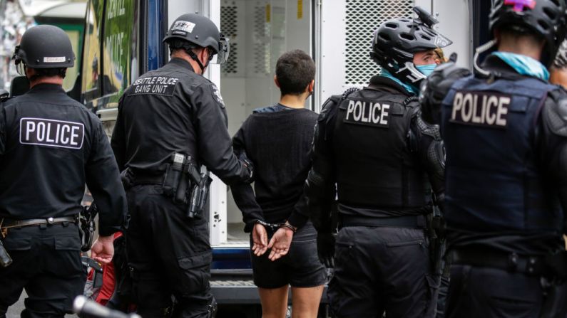 La policía de Seattle arrestó a una mujer luego de que los alborotadores bloquearan la intersección de la calle East Pine con la 11ª Avenue tras el desalojo de la Capitol Hill Occupied Protest (CHOP) en Seattle, Washington, el 1 de julio de 2020. (JASON REDMOND/AFP a través de Getty Images)
