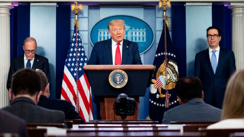 El Presidente de Estados Unidos, Donald Trump, con el Director del Consejo Económico Nacional Larry Kudlow (izquierda) y el Secretario del Tesoro de Estados Unidos, Steven Mnuchin, habla a la prensa en la sala de reuniones Brady de la Casa Blanca en Washington, DC, el 2 de julio de 2020. (JIM WATSON/AFP vía Getty Images)