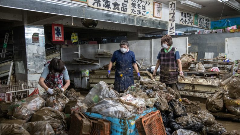 Las mujeres trabajan para limpiar los bienes arruinados de un supermercado que se inundó después de que las lluvias torrenciales causaron que el cercano río Kuma se desbordara y sumergiera el área, el 9 de julio de 2020 en Hitoyoshi, Japón. (Foto de Carl Court/Getty Images)