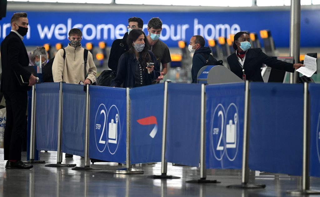 Pasajeros con mascarillas debido a la pandemia de COVID-19, hacen cola en un mostrador de facturación de British Airways en el aeropuerto de Heathrow, al oeste de Londres (Inglaterra), el 10 de julio de 2020. (Foto de DANIEL LEAL-OLIVAS/AFP vía Getty Images)