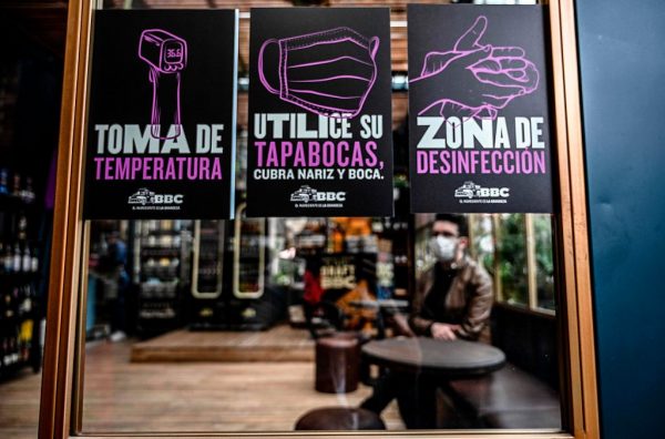 Los signos que muestran medidas preventivas contra la propagación del COVID-19 se muestran en un restaurante durante una prueba piloto de reapertura en Bogotá (Colombia), el 10 de julio de 2020. (Foto de JUAN BARRETO/AFP vía Getty Images)