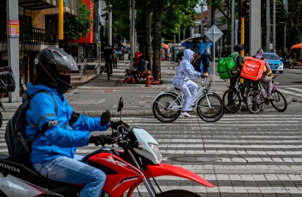Una mujer monta en bicicleta con un traje protector contra la propagación del COVID-19, en Bogotá (Colombia) el 10 de julio de 2020. (Foto de JUAN BARRETO/AFP vía Getty Images)