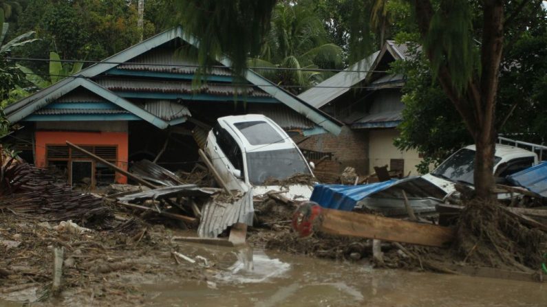 Una vista general muestra vehículos arrastrados por inundaciones repentinas junto a casas en la aldea de Radda en la regencia de North Luwu, Sulawesi del Sur (Indonesia), el 14 de julio de 2020, después de que tres ríos se desbordaran debido a las lluvias torrenciales. (Foto de ARYANTO/AFP vía Getty Images)