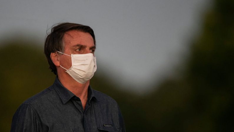 El presidente brasileño Jair Bolsonaro se pone una máscara facial frente a la residencia oficial después de dar positivo en el test de COVID-19 en el Palacio Alvorada el 15 de julio de 2020 en Brasilia, Brasil. (Foto de Bruna Prado/Getty Images)