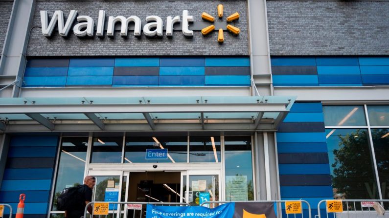 Un hombre camina cerca de un cartel que informa a los clientes que es obligatorio usar cubiertas faciales frente a una tienda Walmart en Washington, DC el 15 de julio de 2020. (ANDREW CABALLERO-REYNOLDS/AFP vía Getty Images)
