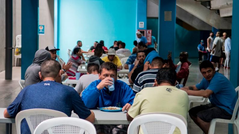 La gente almuerza en un gimnasio que fue convertido en un refugio para los desamparados en medio de la pandemia del COVID-19, en San José (Costa Rica), el 13 de julio de 2020. (Foto de EZEQUIEL BECERRA/AFP vía Getty Images)