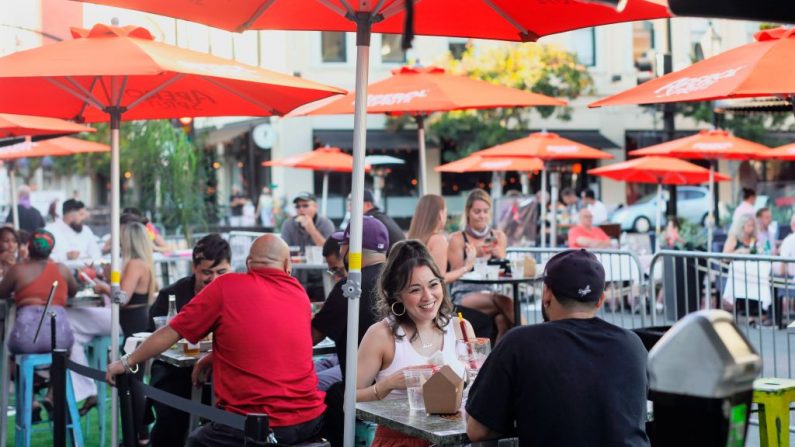Los clientes cenan en un restaurante al aire libre en la 5ª Avenida en el barrio de Gaslamp en el centro de San Diego, California, el 17 de julio de 2020. (Foto de SANDY HUFFAKER/AFP vía Getty Images)