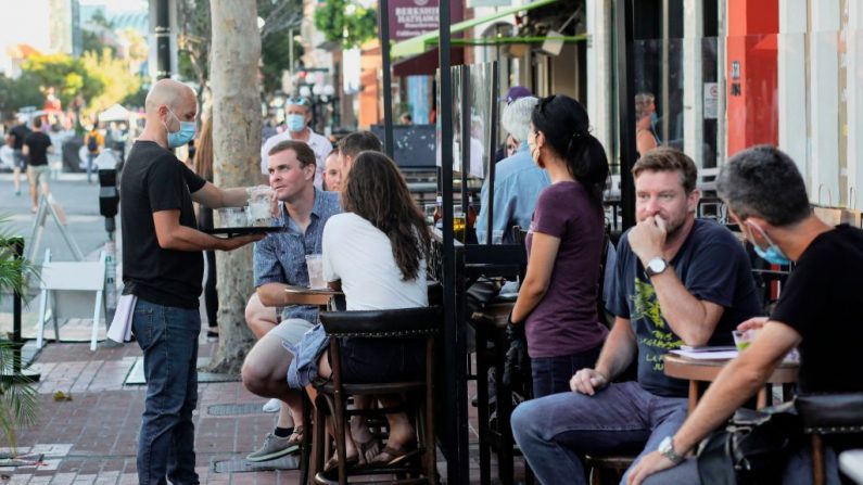 Los clientes cenan en un restaurante al aire libre en la 5ª Avenida en el barrio de Gaslamp en el centro de San Diego, California, el 17 de julio de 2020. (Foto de SANDY HUFFAKER/AFP vía Getty Images)