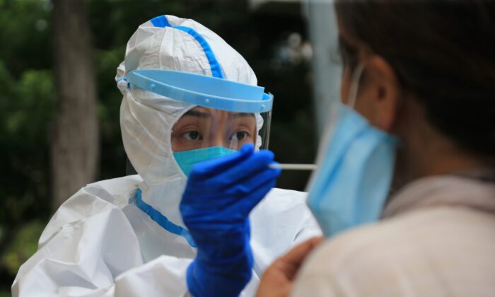 Una trabajadora de la salud realiza una prueba de COVID-19 en Dalian, en la provincia de Liaoning, al noreste de China, el 26 de julio de 2020. (STR/AFP vía Getty Images)