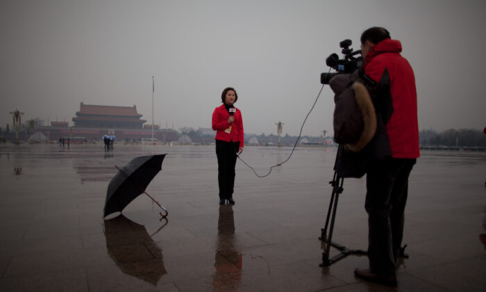 Una reportera de la televisión local china realiza un informe desde la Plaza Tiananmen, en Beijing, el 12 de marzo de 2013. (Ed Jones/AFP a través de Getty Images)