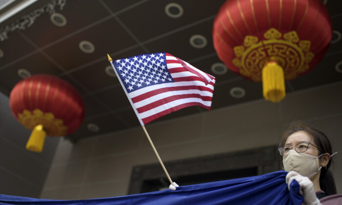 Un manifestante sostiene una bandera estadounidense frente al consulado chino en Houston el 24 de julio de 2020, después de que el Departamento de Estado de EE.UU. ordenara a China su cierre. (MARCAR FELIX/AFP /AFP vía Getty Images)
