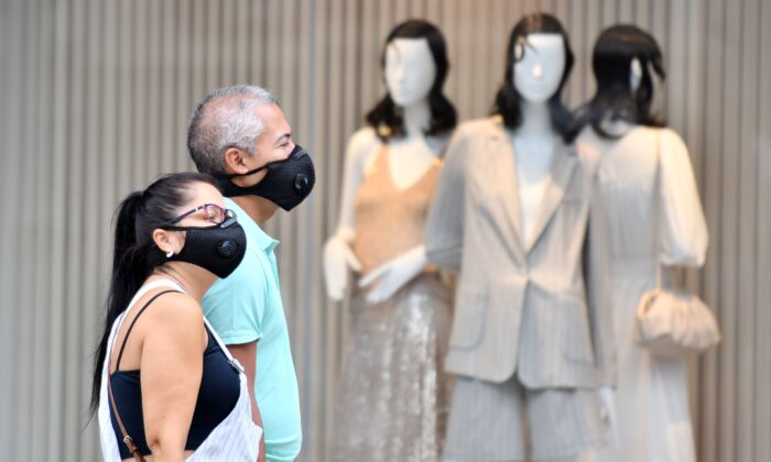 Los compradores usan máscaras como precaución contra la transmisión del nuevo coronavirus cuando pasan por un mostrador, en Oxford Street, en Londres, el 14 de julio de 2020. (Justin Tallis/AFP a través de Getty Images)