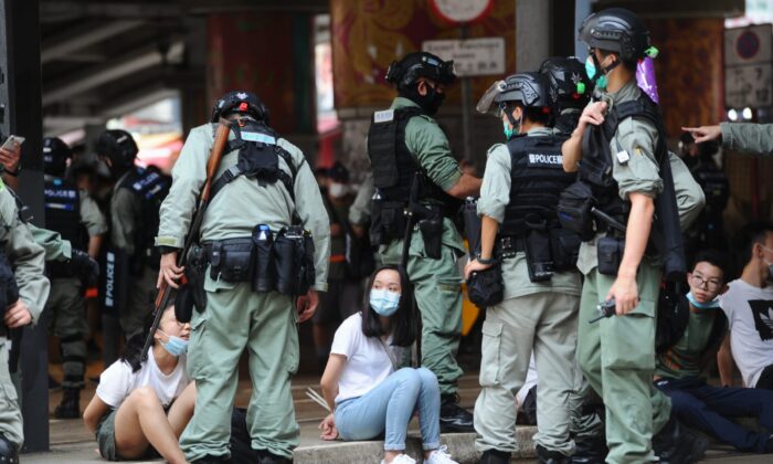 Dos manifestantes son arrestados por la policía en Causeway Bay (Hong Kong) el 1 de julio de 2020. (Song Bilung/The Epoch Times)