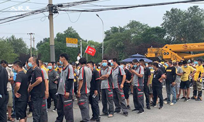 Varios carteros se ponen en fila delante de una clínica que realiza tests de COVID-19 en la ciudad de Sijiqing en Haidian (China), el 22 de junio de 2020. (The Epoch Times)