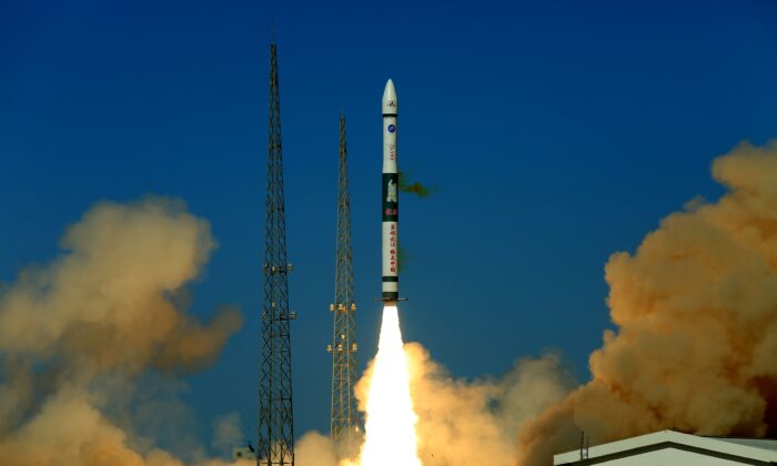 Un cohete portador Kuaizhou-1A con un eslogan de caracteres chinos que dice "Heroico Wuhan, Gran China" despega del Centro de Lanzamiento de Satélites de Jiuquan, en la provincia noroccidental de Gansu, China, transportando dos satélites de comunicaciones el 12 de mayo de 2020. (STR/AFP a través de Getty Images)