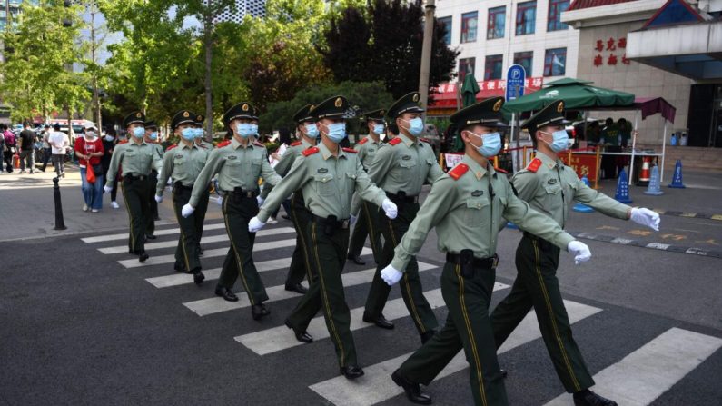 Oficiales de policía paramilitar patrullan en una zona comercial el día de la clausura de la Conferencia Consultiva Política del Pueblo Chino (CPPCC) en Beijing el 27 de mayo de 2020. (Greg Baker/AFP vía Getty Images)