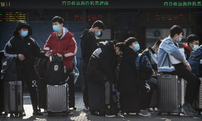 BEIJING, CHINA - Estudiantes chinos usan mascarillas mientras esperan a tomar un tren después de las vacaciones de Año Nuevo chino en Beijing, China, el 31 de enero de 2020. (Kevin Frayer/Getty Images)