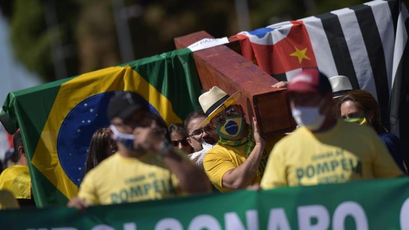 Simpatizantes del presidente brasileño, Jair Bolsonaro, se manifiestan en su apoyo y en solidaridad luego de que el mandatario salió positivo en una prueba de covid-19, este domingo, en la Explanada de los Ministerios, en Brasilia (Brasil). EFE/Andre Sousa Borges
