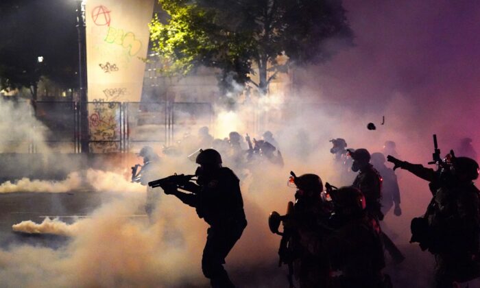 Los oficiales federales despliegan gases lacrimógenos y municiones de baja letalidad mientras dispersan a una multitud del Palacio de Justicia, Mark O. Hatfield, en Portland, Oregon, el 24 de julio de 2020. (Nathan Howard/Getty Images)