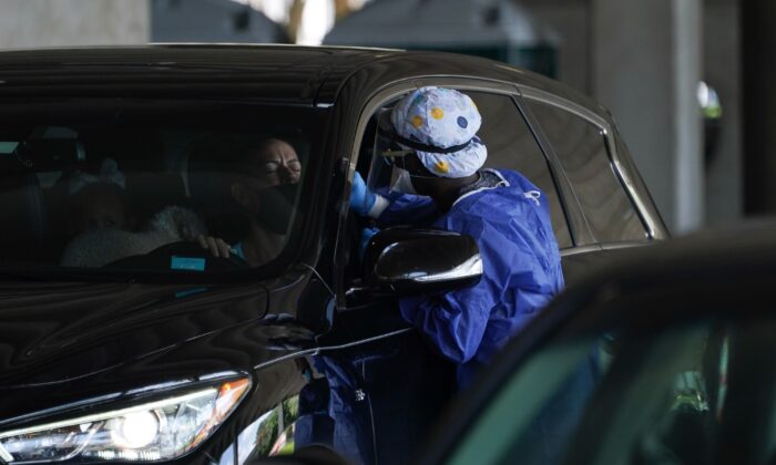 Una médica toma un hisopo de un conductor en un sitio de pruebas de COVID-19 en el Teatro Mahaffey en San Petersburgo, Florida, el 24 de julio de 2020. (Bryan R. Smith/AFP vía Getty Images)
