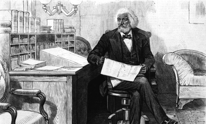 El orador, editor, autor, abolicionista y exesclavo americano Frederick Douglass (1818-1895) edita una revista en su escritorio, a finales de la década de 1870. (Archivo Hulton/Getty Images)