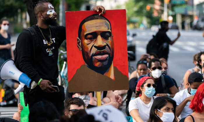 Un hombre sostiene una foto de George Floyd durante una protesta de Black Lives Matter en la ciudad de Nueva York el 18 de junio de 2020. (Jeenah Moon/Getty Images)