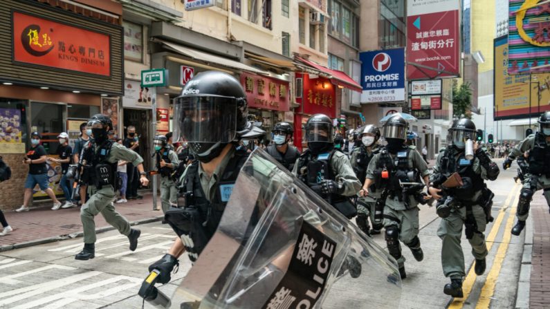 La policía antidisturbios corre en una calle hacia los peatones durante una operación de control de multitudes en una manifestación en Hong Kong, el 1 de julio de 2020. (Anthony Kwan/Getty Images)