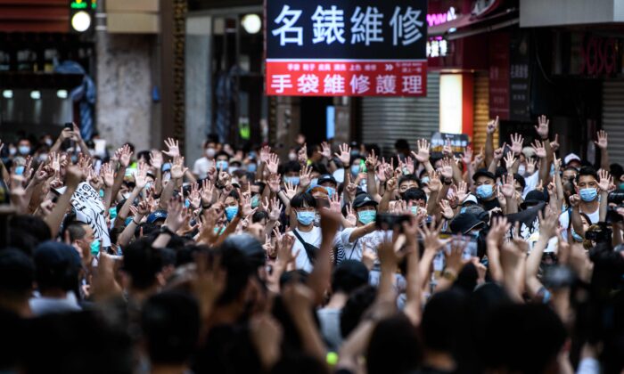Unos manifestantes cantan eslóganes y hacen gestos durante una manifestación contra una nueva ley de seguridad nacional en Hong Kong el 1 de julio de 2020. (Anthony Wallace/AFP vía Getty Images)