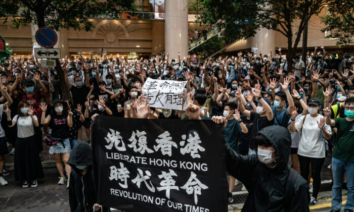 La policía antidisturbios detiene a un hombre mientras levantan una bandera de advertencia durante una manifestación contra la nueva ley de seguridad nacional en Hong Kong, el 1 de julio de 2020. (Anthony Kwan/Getty Images)