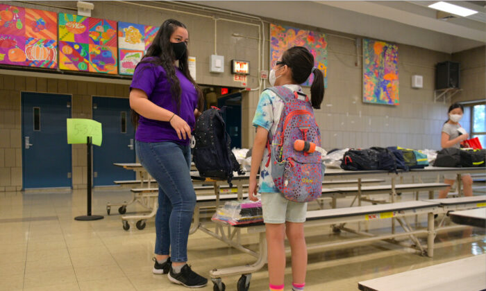 La maestra Aurora Chen da un regalo del comité de graduados a un estudiante que se acaba de graduar en la escuela Yung Wing School P.S. 124 en Nueva York el 29 de junio de 2020. (Michael Loccisano/Getty Images)
