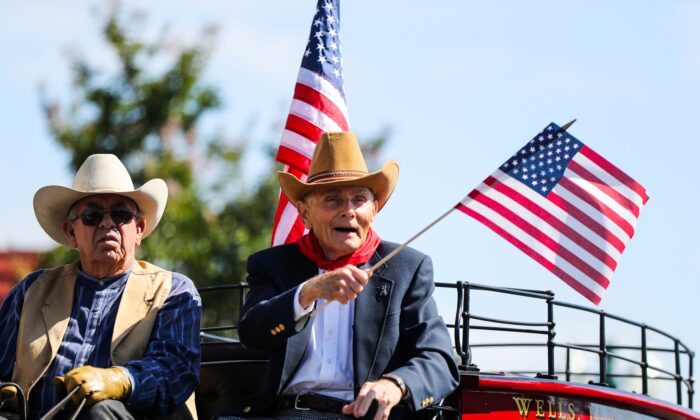 Un hombre agita una bandera estadounidense mientras monta un carruaje en el desfile del 4 de julio, en Alameda, California, el lunes 4 de julio de 2016 - Foto de archivo. (GABRIELLE LURIE/AFP vía Getty Images)