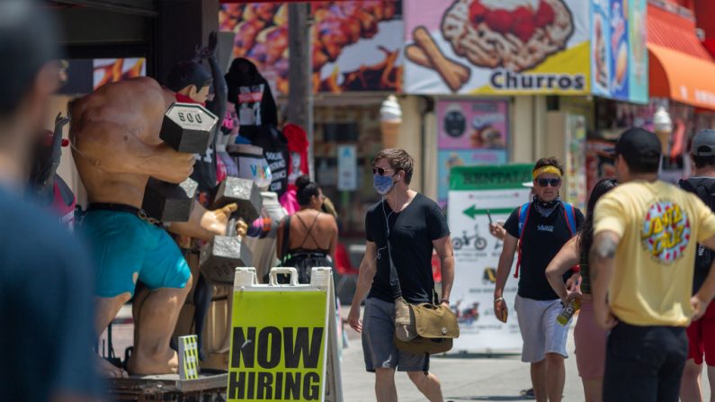 Una tienda anuncia una vacante de trabajo mientras que los turistas van a Venice Beach el Día de la Recordación (Memorial Day) mientras que las restricciones de seguridad contra el COVID-19 se siguen relajando en el condado de Los Ángeles y en todo el país el 24 de mayo de 2020 en Los Ángeles, California. (David McNew/Getty Images)