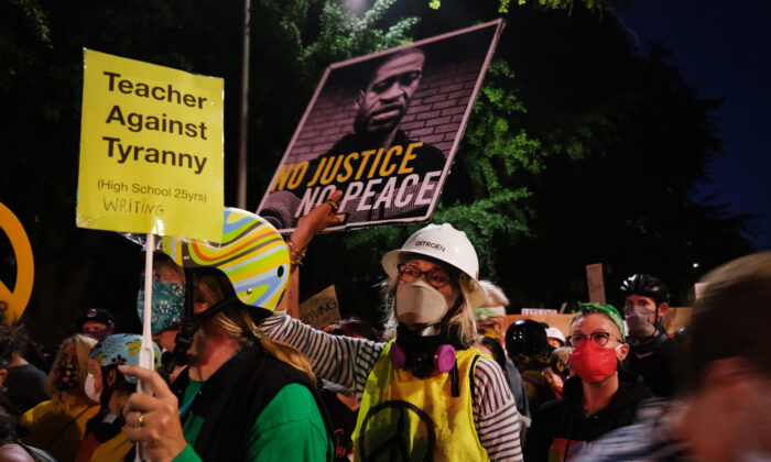 La gente se reúne frente al Tribunal de Mark O. Hatfield en el centro de Portland mientras la ciudad experimenta otra noche de disturbios, el 24 de julio de 2020. (Spencer Platt/Getty Images)