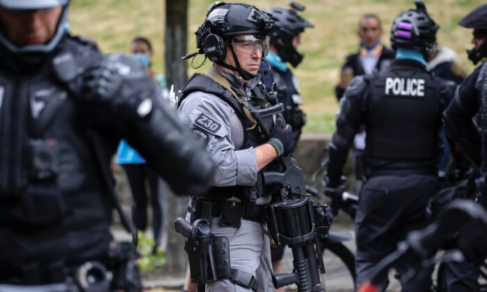 Un oficial de policía de Seattle vigila mientras varias personas son arrestadas cerca de la recientemente llamada Zona Autónoma en Seattle, el 1 de julio de 2020. (Jason Redmond / AFP a través de Getty Images)